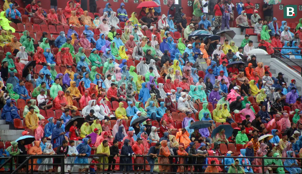 Sejumlah suporter memakai jas hujan saat menyaksikan laga perdana BRI Liga 1 2023/2024 antara Bali United melawan PSS Sleman yang berlangsung di Stadion Kapten I Wayan Dipta, Gianyar, Sabtu (1/7/2023) sore WIB. (Bola.com/Alit Binawan)