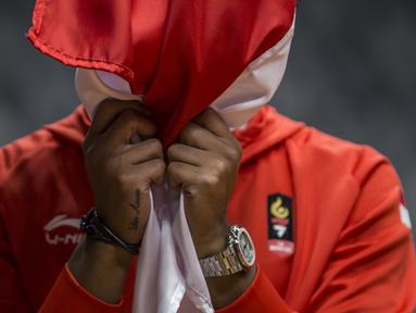 Atlet jetski Indonesia, Agsa Azwar, mencium bendera saat acara pengukuhan kontingen Indonesia di Istora Senayan, Jakarta, Minggu (5/8/2018). Pada Asian Games XVIII, Indonesia menurunkan 938 atlet. (Bola.com/Vitalis Yogi Trisna)