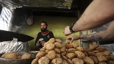 Seorang warga Palestina membuat falafel, makanan yang disukai untuk berbuka puasa, selama bulan suci Ramadhan di pusat kota kota Hebron di Tepi Barat yang diduduki (9/4/2022). Falafel adalah sebuah makanan Timur Tengah. (AFP/Hazem Bader)