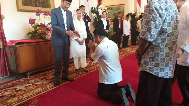 Seorang warga sujud saat bersamalan dengan Jokowi dan Iriana