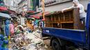 Pekerja membersihkan puing-puing di Pasar Namseong yang bersejarah di distrik Gangnam Seoul (9/8/2022).  Dilansir Yonhap, Selasa (9/8/2022), hujan yang terjadi di Korea Selatan adalah yang terparah dalam 80 tahun terakhir. (AFP/Anthony Wallace)