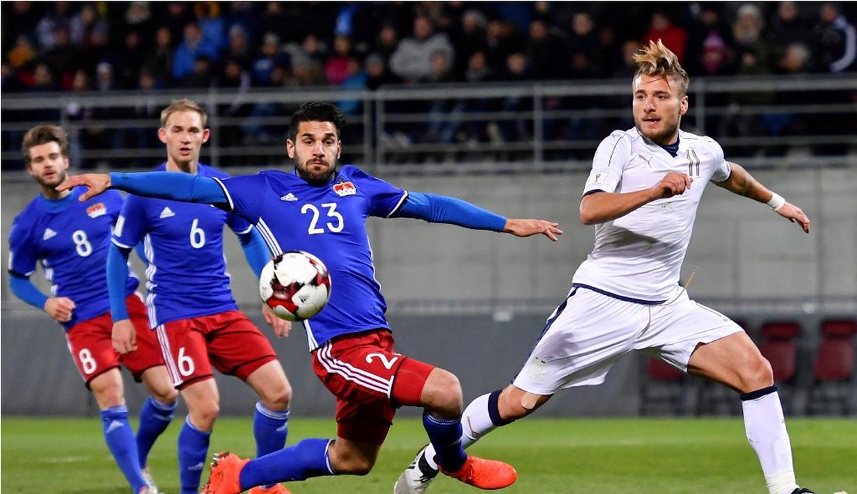 Pemain Italia, Ciro Immobile (kanan), berebut bola dengan pemain Liechtenstein, Michele Polverino, dalam laga Grup G Kualifikasi Piala Dunia 2018 di Stadion Rheinpark, Minggu (13/11/2016) dinihari WIB. (AFP/Fabrice Coffrini)