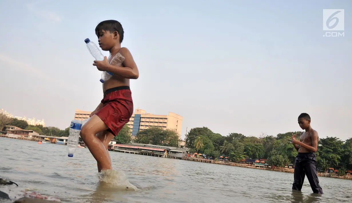 Anak-anak selesai berenang di Danau Sunter, Jakarta, Selasa (23/7/2019). Minimnya fasilitas bermain yang layak dan murah membuat anak-anak nekat berenang di Danau Sunter. (merdeka.com/Iqbal Nugroho)