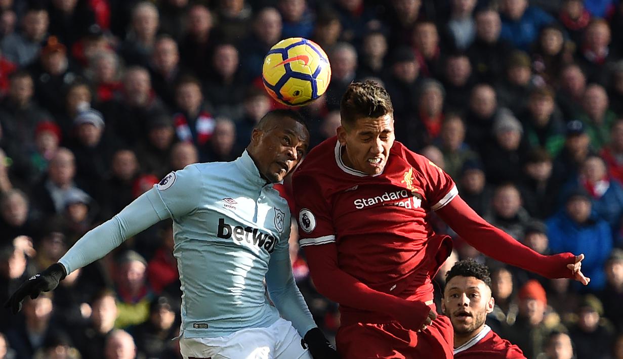 Duel pemain West Ham United, Patrice Evra (kiri) dan pemain Liverpool, Roberto Firmino pada laga Premier League pekan ke-28 di Anfield Stadium, Liverpool, (24/2/2018). Liverpool menang 4-1. (AFP/Oli Scarff)