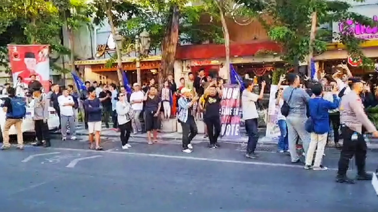 Sekelompok orang yang berada di seberang jalan atau depan lokasi deklarasi Anies-Cak Imin di Surabaya, menyanyikan Ganjar Presiden