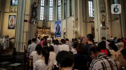 Romo memimpin misa malam Natal di Gereja Katedral, Jakarta, Selasa (24/12/2019). Jemaat memenuhi area dalam dan luar gereja. (Liputan6.com/Faizal Fanani)