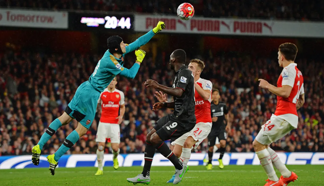 Kiper Arsenal, Petr Cech (kiri) berusaha menghalau bola dari kejaran Penyerang Liverpool, Christian Benteke dalam pertandingan Liga Primer Inggris di Stadion Emirates, Inggris, (24/8/2015). Kedua tim bermain imbang dengan skor 0-0. (Reuters/Tony O'Brien)