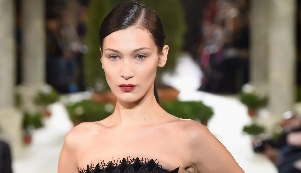 <p>Model Bella Hadid berpose mengenakan gaun hitam koleksi terbaru dari Oscar de la Renta berjalan di atas catwalk selama New York Fashion Week, AS (12/2). Gaun yang dikenakan Bella Hadid dihiasi motif simetris. (AFP Photo/Slaven Vlasic)</p>