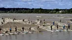 Sejumlah warga berselancar di Sungai Dordogne, Saint-Pardon, Prancis (24/7). Fenomena pasang surut besar yang menyebabkan gelombang arus di Sungai Dordogne ini dimanfaatkan warga dan turis unutk berselancar. (AFP Photo/Georges Gobet)