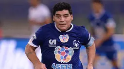 Aksi Maradona saat mengiring bola pada pertandingan amal 'United for Peace' di stadion Olimpyco, Roma, Italia (12/10). Tim Maradona takluk dalam pertandingan amal ini dengan skor 4-3. (AFP Photo/Filippo Monteforte)