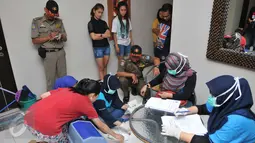 Petugas BNN melakukan pendataan penghuni kos-kosan di Jalan Taman Sari Raya No 60-62, Jakarta (1/10/15). Dari razia ini, delapan orang terdiri dari tujuh wanita dan satu pria diamankan karena positif mengonsumsi narkoba. (Liputan6.com/Gempur M Surya)