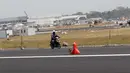 Pekerja melintasi sisi landasan pacu atau runway Bandara Internasional Yogyakarta, Kulon Progo, DI Yogyakarta, Rabu (24/4). Landasan pacu Bandara Internasional Yogyakarta memiliki panjang 3.250 meter dengan lebar 45 meter. (Liputan6.com/Helmi Fithriansyah)