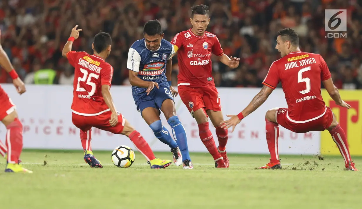 Tiga pemain Persija mencoba menahan pergerakan penyerang Arema FC, Dedik Setiawan pada babak pertama lanjutan Liga 1 Indonesia 2018 di Stadion GBK, Jakarta, Sabtu (31/3). (Liputan6.com/Helmi Fithriansyah)