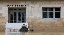 Layanan cuaca nasional Meteo-France mengatakan bahwa negara itu mengalami rangkaian musim hujan terpanjang sejak pemantauan dimulai pada tahun 1959. Tampak foto menunjukkan kondisi toko kue yang terendam banjir akibat hujan lebat yang menyebabkan luapan sungai Garonne di Sainte-Croix-du-Mont, Prancis barat pada Kamis 19 Februari 2026. (ROMAIN PERROCHEAU/AFP)