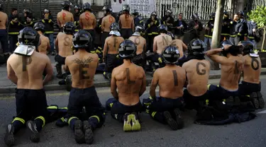Petugas pemadam kebakaran ambil bagian dalam aksi protes di depan gedung parlemen di Oviedo, Spanyol, Kamis (19/11). Mereka melakukan aksi mogok bertugas guna menuntut kenaikan gaji dan tunjangan kesejahteraan. (REUTERS/Eloy Alonso)