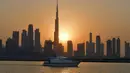 Matahari terbenam di belakang bangunan tertinggi di dunia Burj Khalifa dan gedung-gedung bertingkat lainnya, di Dubai, Uni Emirat Arab pada Sabtu (12/9/2020). (Photo by Karim SAHIB / AFP)