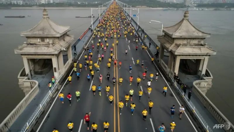 Pelari maraton Wuhan menyeberangi jembatan Sungai Yangtze pada tahun 2018. Acara tahun ini ditunda dalam waktu singkat karena kekhawatiran COVID-19. (Foto: AFP)