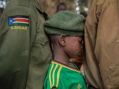 Seorang tentara anak yang baru dibebaskan menunggu dalam antrean di Yambio, Sudan Selatan, (7/2). Sebanyak 311 tentara anak-anak, termasuk 87 anak perempuan, telah dibebaskan oleh kelompok bersenjata di Sudan Selatan. (AFP PHOTO/Stefanie Glinski)