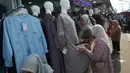 Warga berbelanja pakaian sebagai persiapan perayaan Idul Fitri di salah satu pasar musiman di Jakarta, Senin 9 Maret 2026. Pasar Tasik Cideng menjadi alternatif bagi warga Jakarta dan sekitarnya mencari pakaian khas muslim yang mengikuti tren terkini, mulai dari gamis, tunik, hingga aneka busana Lebaran berkualitas. (AP Photo/Achmad Ibrahim)