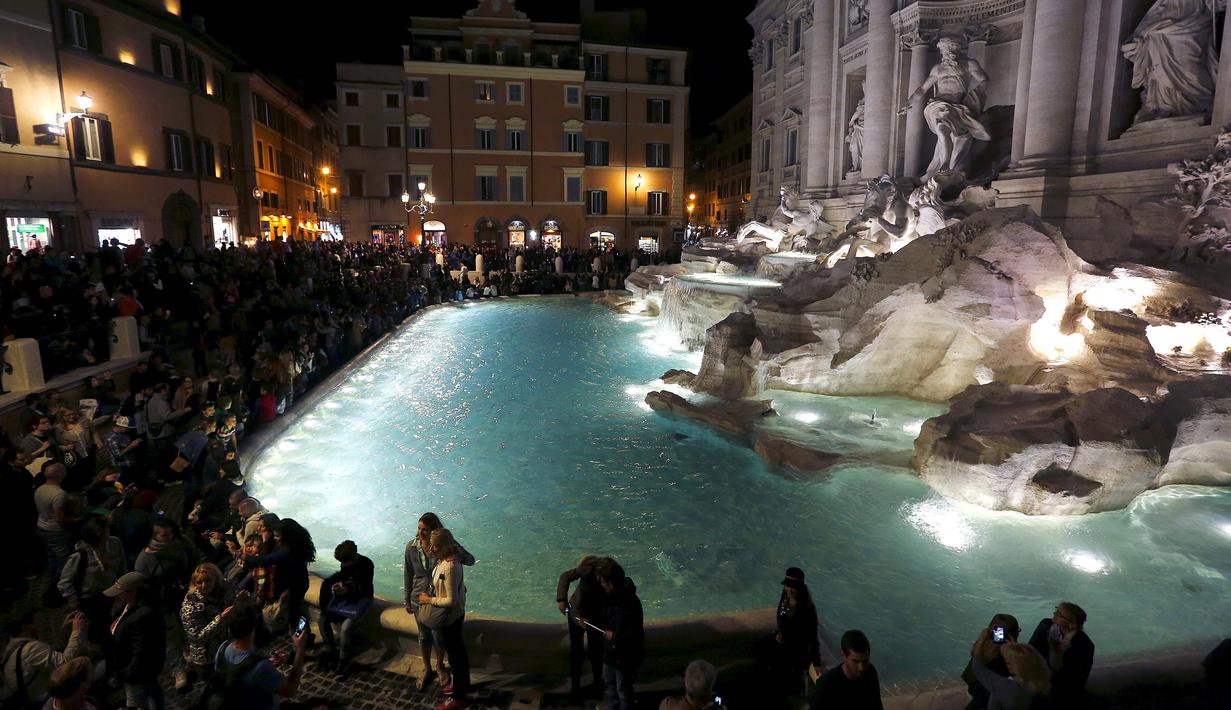 Pengunjung menghadiri peresmian air mancur Trevi Fountain setelah ditutup untuk renovasi, Roma, Selasa (3/11). Renovasi digagas oleh salah satu brand fashion Italia, Fendi, dengan biaya sebesar 2,2 juta Euro (Rp 32 m). (REUTERS/Alessandro Bianchi)