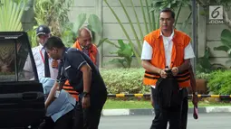 Deputi IV Kementerian Pemuda dan Olahraga Mulyana dan Manajer Legal PT Bina Sawit Abadi Pratama, Teguh Dudy Syamsuri Zaldy (kanan) turun dari mobil tahanan saat tiba di gedung KPK, Jakarta, Kamis (14/2). (Merdeka.com/Dwi Narwoko)