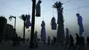 Matahari terbenam terlihat dari atas gaun pengantin yang digantung di antara pohon palem di tepi pantai Beirut, Sabtu (22/4). Gaun yang digantung itu sebagai bentuk protes Undang-Undang Pemerkosaan di Lebanon oleh sekelompok aktivis. (PATRICK BAZ/AFP)