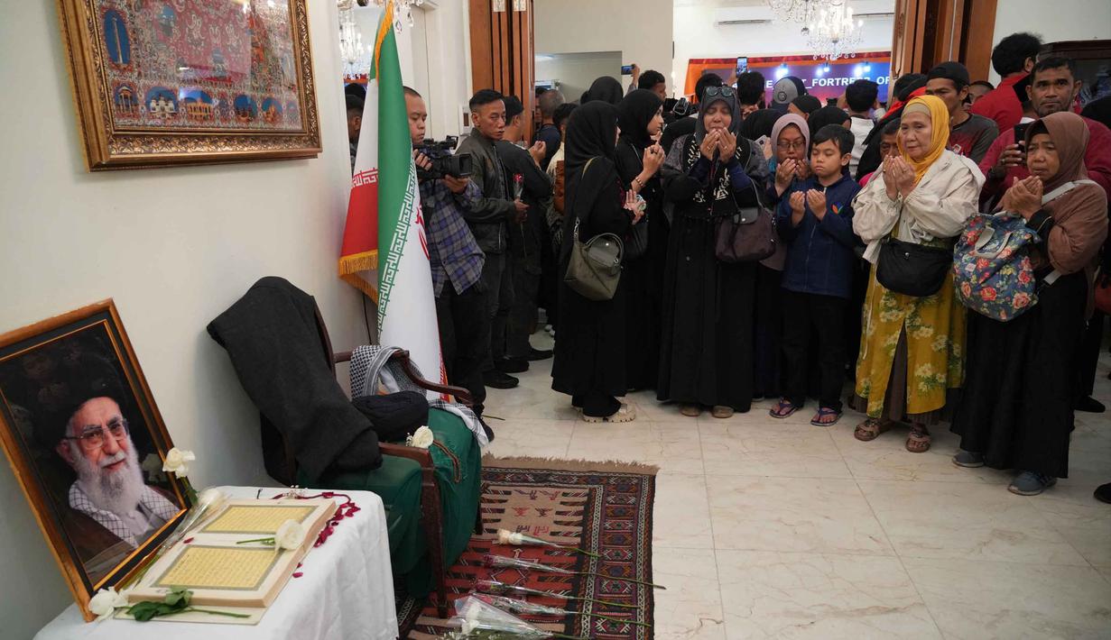 Para pelayat berdoa di dekat potret mendiang Pemimpin Tertinggi Iran, Ayatollah Ali Khamenei, di kediaman duta besar Iran untuk Indonesia, Jakarta, Kamis 5 Maret 2026. Ratusan masyarakat memadati kediaman Duta Besar Republik Islam Iran untuk Indonesia di Jakarta. (AP Photo/Tatan Syuflana)