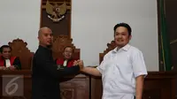 Musisi Ahmad Dhani dan Farhat Abbas melakukan salam komando seusai menjalani sidang lanjutan kasus pencemaran nama baik yang dilayangkan Ahmad Dhani di Pengadilan Negeri Jakarta Selatan, Kamis (19/11). (Liputan6.com/Herman Zakharia)