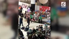 Penjaga toko menghibur penumpang di Bandara Gatwick, London. Diketahui sejumlah penerbangan ditunda dan ratusan penumpang terlantar karena dua drone terbang di sekitar bandara.