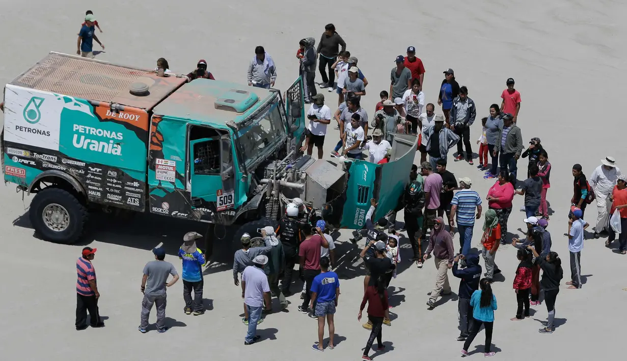 Penonton mengelilingi truk pengemudi Iveco Ton Van Genugten dan rekannya Bernard Der Kinderen, dari Belanda, pada tahap 11 Reli Dakar 2018 antara Belen dan Chilecito / Fiambala, Argentina, (17/1). (AP Photo / Ricardo Mazalan)