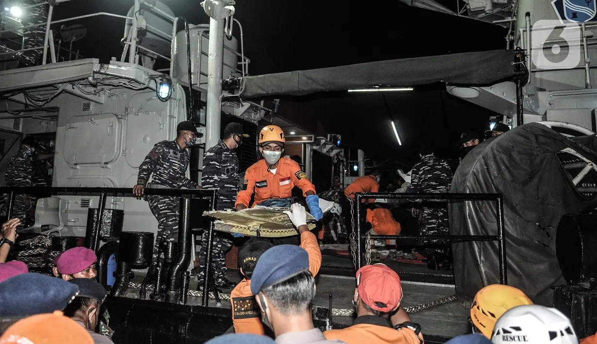 Tim SAR gabungan menurunkan serpihan pesawat Sriwijaya Air SJ 182 saat tiba di Dermaga JICT 2, Tanjung Priok, Jakarta, Minggu (10/1/2021). Pencarian Sriwijaya Air SJ 182 tetap dilakukan pada malam hari meski secara terbatas. (merdeka.com/Iqbal S. Nugroho)