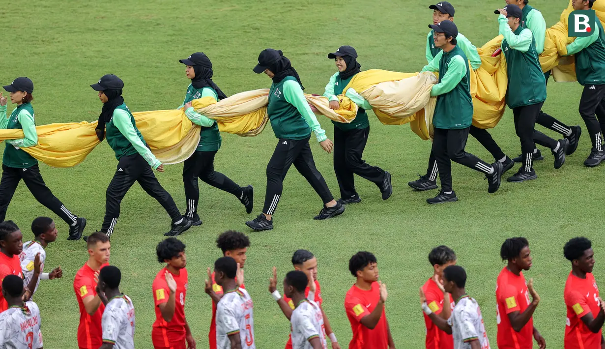 Sejumlah petugas membawa benedera ke luar dari lapangan menjelang laga Piala Dunia U-17 2023 antara Timnas Mali U-17 melawan Timnas Kanada U-17 di Stadion Gelora Bung Tomo (GBT), Surabaya, Kamis (16/11/2023). (Bola.com/Bagaskara Lazuardi)