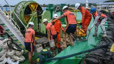 Personel penjaga pantai Filipina memuat peralatan skimmer yang akan digunakan dalam penanggulangan tumpahan minyak di sebuah pelabuhan di Limay, Bataan pada tanggal 26 Juli 2024. (Jam Sta Rosa/AFP)