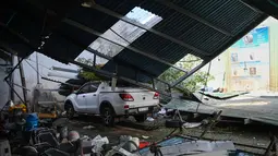 Dengan membawa angin kencang berkecepatan hingga 183 km/jam, terjangan Topan Kalmaegi menyebabkan kerusakan yang cukup luas, pemadaman listrik massal, serta hujan lebat yang memicu banjir. Tampak dalam foto, sebuah kendaraan tertimpa struktur atap yang runtuh di kawasan pesisir Quy Nhon, Provinsi Gia Lai, Vietnam Tengah, pada Jumat 7 November 2025. (NHAC NGUYEN/AFP)