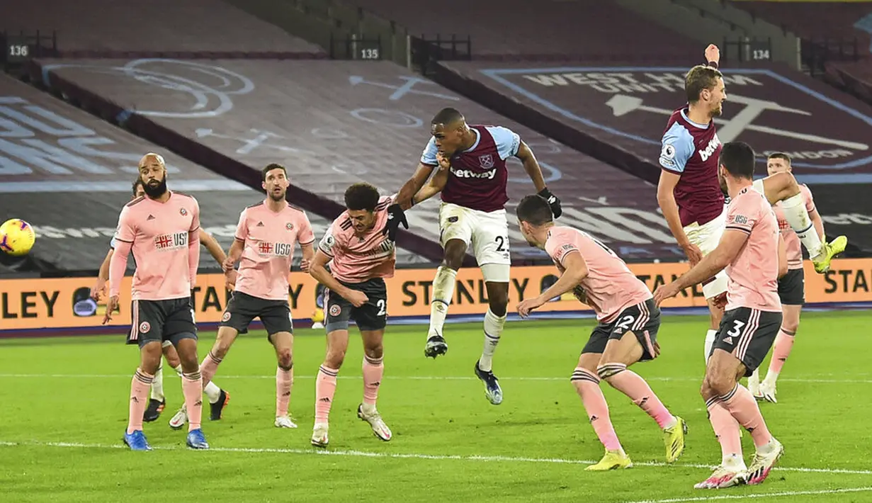 Pemain West Ham United Issa Diop (tengah) mencetak gol ke gawang Sheffield United pada pertandingan Liga Inggris di London Stadium, London, Inggris, Senin (15/2/2021). West Ham United menang 3-0. (Glyn Kirk/Pool via AP)