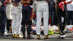 Para pebalap F1 meletakkan helm di tengah lingkaran saat mengheningkan cipta selama satu menit sebelum memulai balapan. (Reuters/Laszlo Balogh)