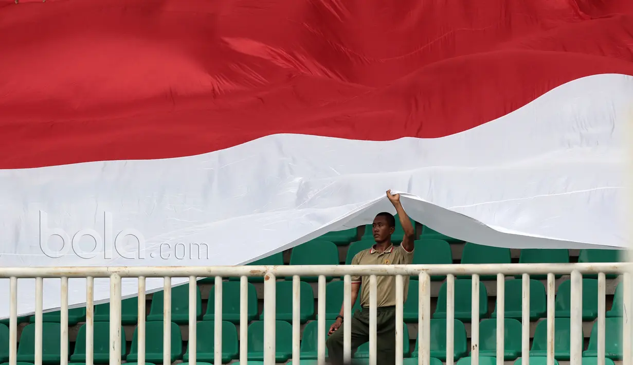 Pendukung PS TNI membentangkan bendera Merah-Putih saat timnya melawan Persiba Balikapapan pada Liga 1 2017 di Stadion Pakansari, Bogor, Jumat (5/5/2017). PS TNI dan Persiba bermain imbang 1-1.  (Bola.com/Nicklas Hanoatubun)