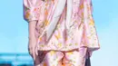 Maya Septha juga mengenakan setelan baju tidur warna pink dengan atasan lengan 3/4 dipadukan celana panjang. Ia juga mengenakan syal putih dan membawa tas coklat. [@sarwendah29]