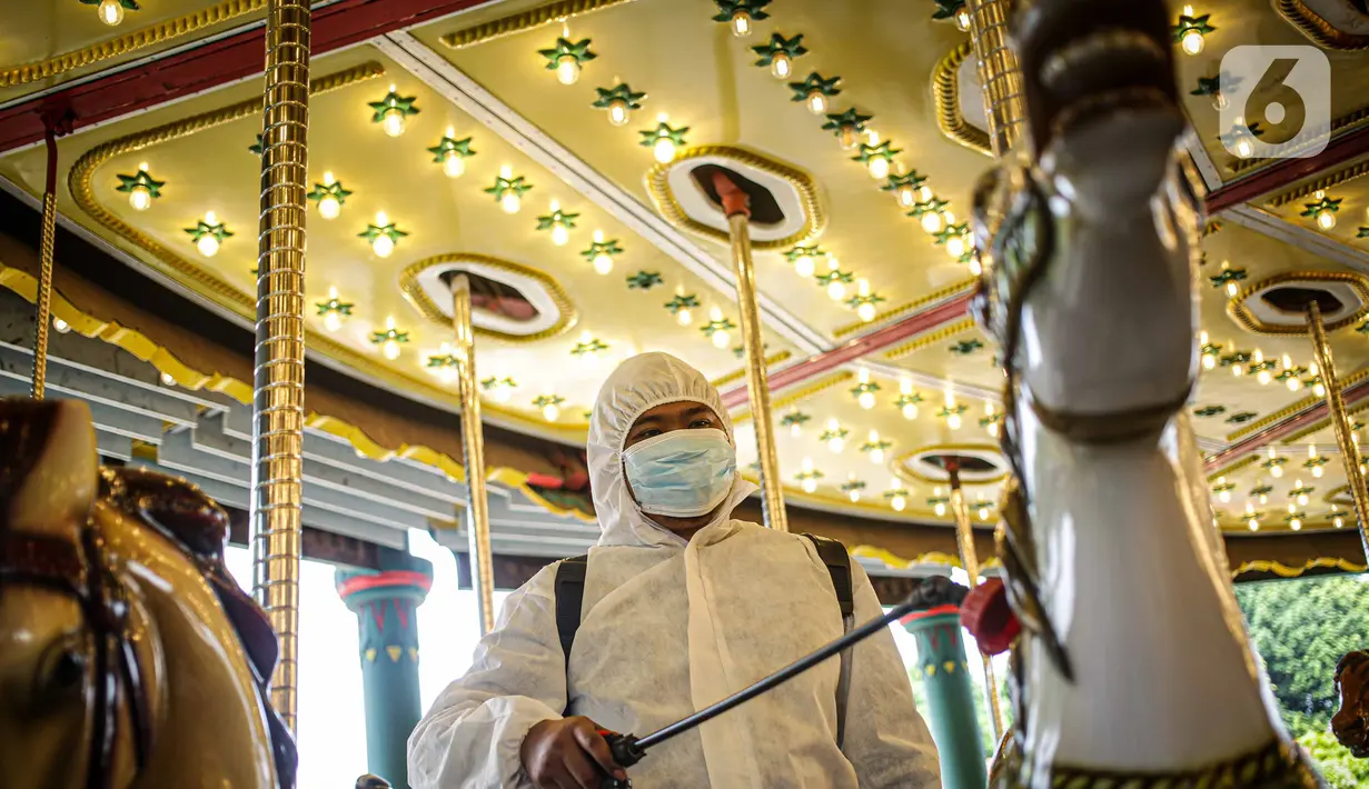 Petugas menyemprotkan disinfektan pada wahana Turangga-rangga di Dunia Fantasi, Taman Impian Jaya Ancol, Jakarta, Sabtu (11/10/2021). Taman Impian Jaya Ancol menjadi salah satu dari 20 destinasi wisata yang direkomendasikan beroperasi kembali dalam uji coba. (Liputan6.com/Faizal Fanani)