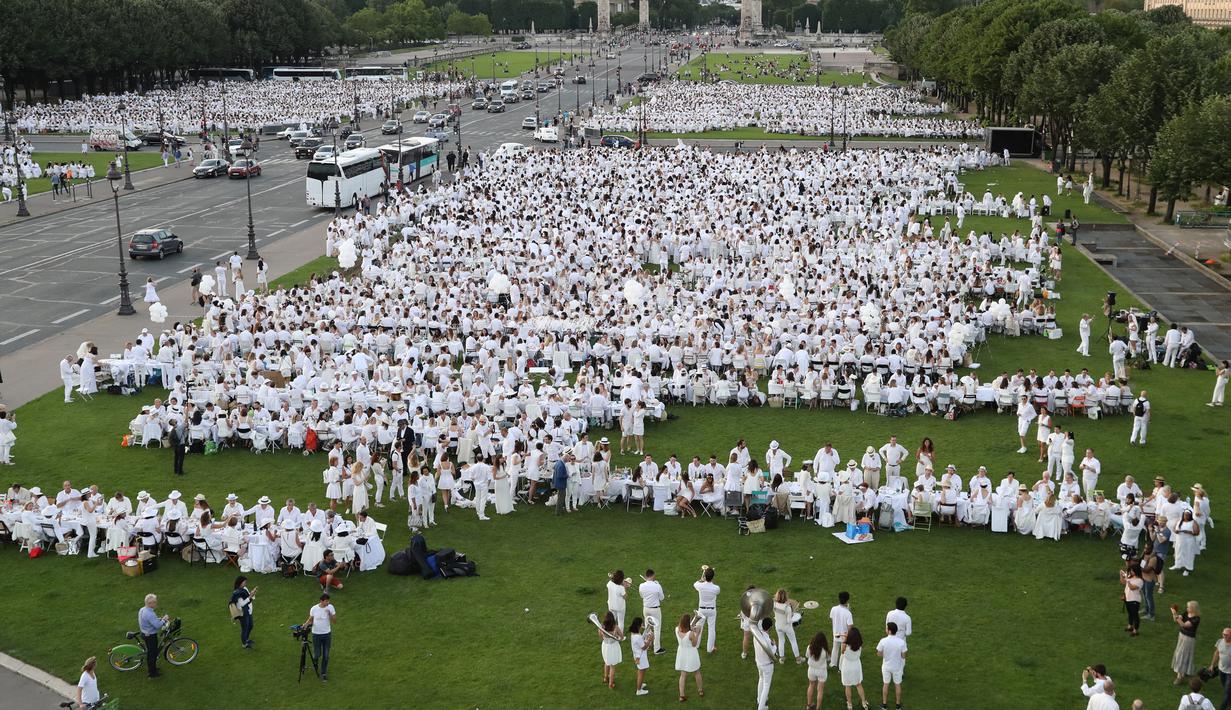 Suasana saat orang-orang berpakaian putih berkumpul untuk makan malam bersama atau "Diner en Blanc" yang ke-30 di Paris, Prancis (3/6). Kini setiap tahun sekurangnya 15.000 orang yang ikut meramaikannya. (AFP/Francois Guillot)