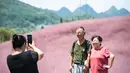 Wisatawan berpose di tengah padang rumput berwarna pink (Muhlenbergia capillaris) di objek wisata Shenquangu di Wilayah Changshun, Provinsi Guizhou, China barat daya  (2/9/2020). (Xinhua/Tao Liang)