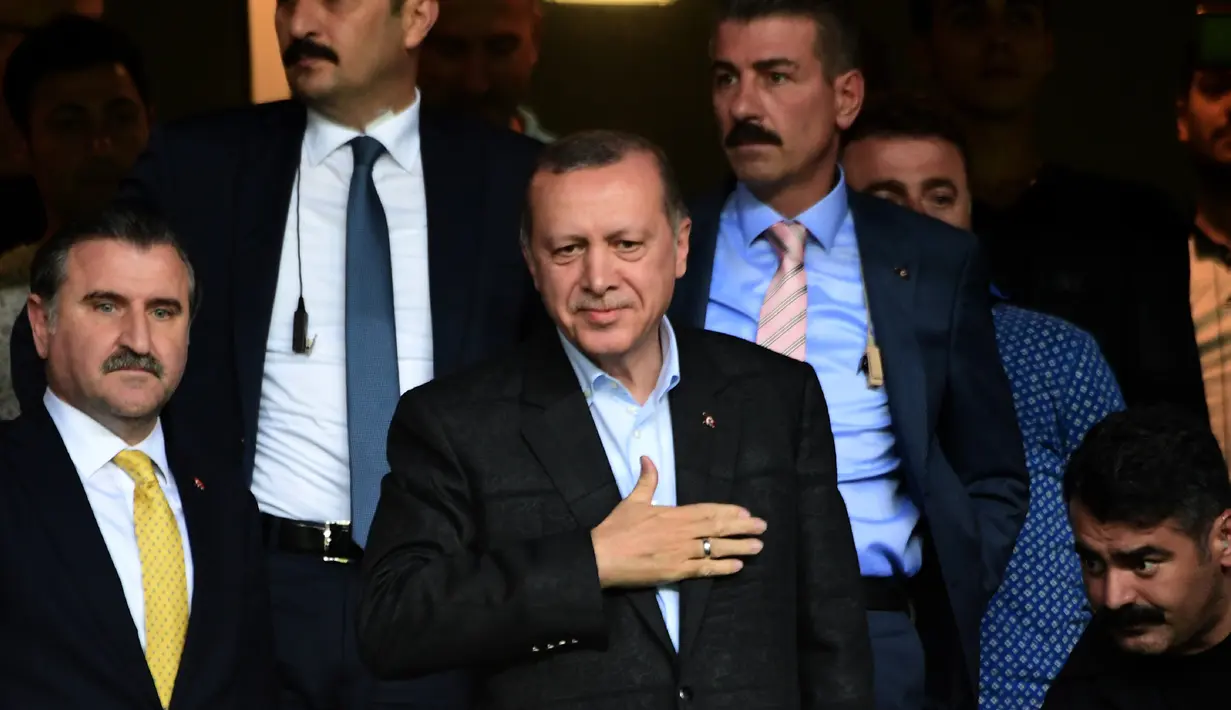 Presiden Turki Recep Tayyip Erdogan menyapa para suporter saat pertandingan Fenerbahce melawan Sturm Graz di Stadion Ulker Fenerbahce di Istanbul (3/8). Fenerbahce menang dengan agregat 3-2. (AFP Photo/Ozan Kose)