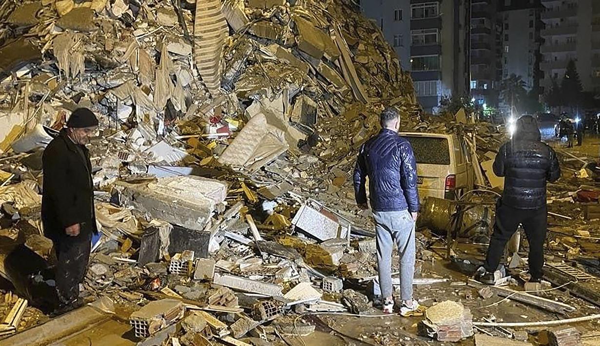 Orang-orang berusaha menjangkau warga yang terperangkap di dalam bangunan yang runtuh di Diyarbakir, Turki selatan, Senin dini hari, 6 Februari 2023. Gempa berkekuatan magnitudo 7,8 telah menyebabkan kerusakan signifikan di tenggara Turki dan Suriah dan dikhawatirkan banyak korban jiwa. (Depo Photos via AP)