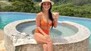 Bikini two pieces warna orange juga nampak terlihat hot dikenakan oleh Indah Kalalo. Ia pun memadukannya dengan topi pantai dan kacamata cokelatnya. (@indahkalalo)