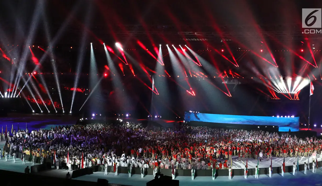Parade atlet dari berbagai negara saat upacara Penutupan Asian Games 2018 di Stadion Utama Gelora Bung Karno, Jakarta, Minggu (2/9). Mereka mengenakan jas hujan yang mengguyur Jakarta. (Liputan6.com/Helmi Fithriansyah)