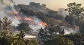 Petugas pemadam kebakaran berupaya memadamkan kebakaran hutan yang terjadi di Ierapetra, pulau Kreta, Yunani selatan, pada Kamis 3 Juli 2025. (Costas Metaxakis/AFP)