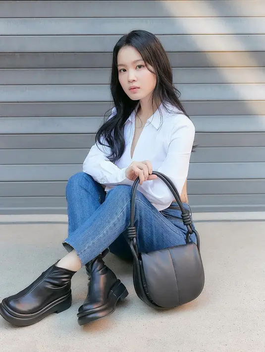Kemeja putih polos dan celana jeans menjadi perpaduan yang tak pernah salah. Wanita yang akan tampil di Indonesia pada November 2022 ini memilih memadukan penampilannya dengan ankle boots serta hand bag hitam polos. (Liputan6.com/IG/@leehi_hi)