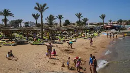 Wisatawan bersantai sembari menikmati mahatari di pantai kota wisata Laut Merah Mesir, Hurghada pada 3 April 2019. Sepanjang tahun Hurghada beriklim tropis, sehingga banyak turis yang datang untuk merasakan musim panas dari bulan Januari sampai Desember. (Mohamed el-Shahed / AFP)
