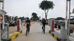 Pengendara sepeda akan melintasi Gate parkir akses masuk RPTRA/RTH Kalijodo, Jakarta, Rabu (3/5). Gate parkir yang terpasang sebanyak 4 palang pintu itu dibagi dua akses masuk dan dua untuk akses keluar. (Liputan6.com/Yoppy Renato)