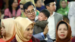 Gibran Rakabuming Raka menggendong anaknya, Jan Ethes Srinarendra yang menangis selama pesta adat pernikahan sang adik, Kahiyang Ayu dengan Bobby Nasution di Bukit Hijau Regency, Medan, Jumat (24/11). (Liputan6.com/Pool/Media Center)
